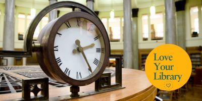 Clock in the Brotherton Library Reading room with the Lover Your Library logo.