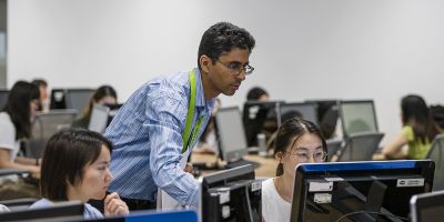 A member of library staff helping a student in a computer room