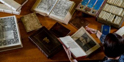 Books from Special Collections open on a table with someone reading them.