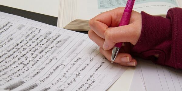 A hand holding a pen making some notes