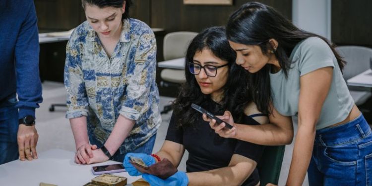 Three women interested in an old book