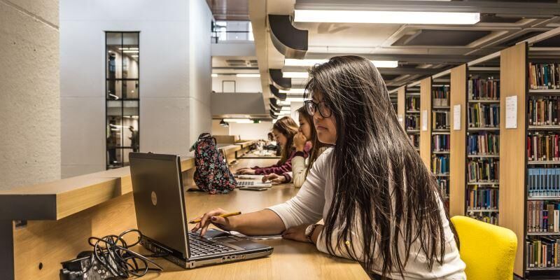Student looking at laptop in Edward Boyle Library